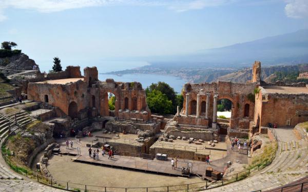 Panoramic view of Taormina with its historic landmarks and Mount Etna in the distance