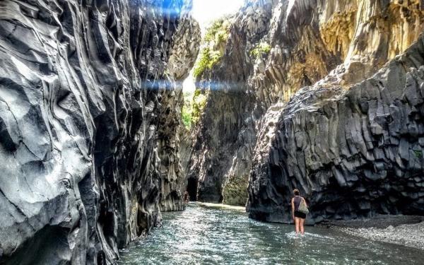 Vertical basalt columns rising above the Alcantara River corridor,