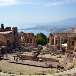 Panoramic view of Taormina with its historic landmarks and Mount Etna in the distance