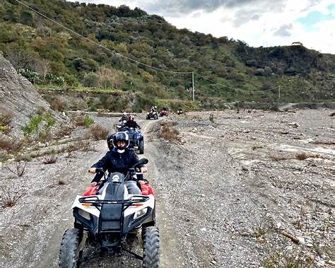 travellers driving quad bikes along rural roads in the Alcantara Valley